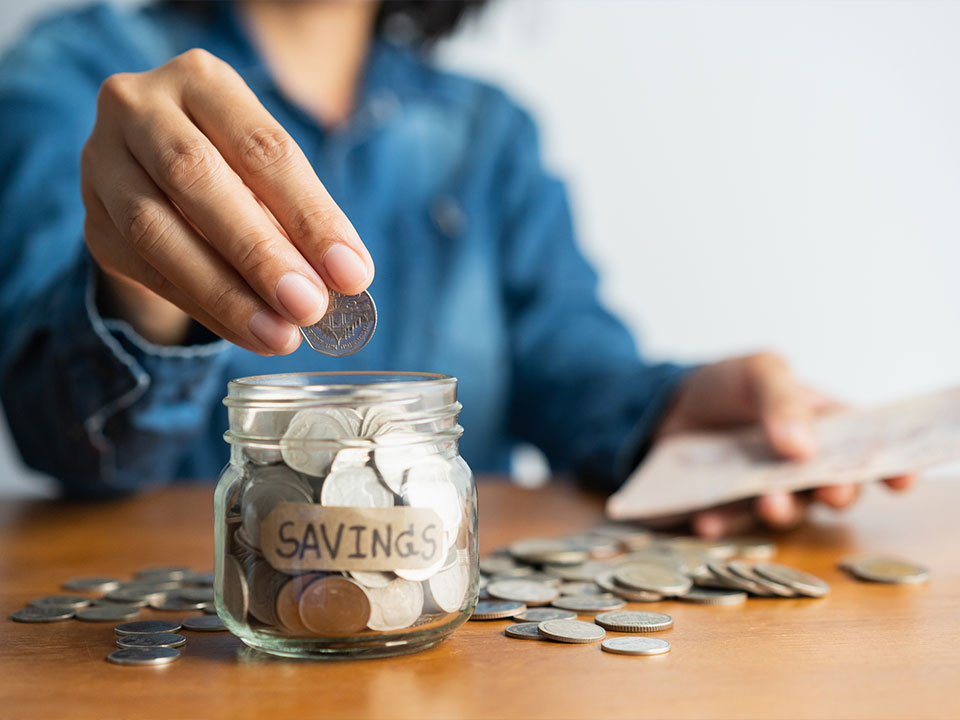 woman putting savings in a jar