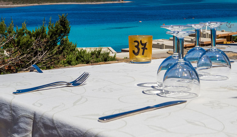 dining table near the ocean with silver table wares