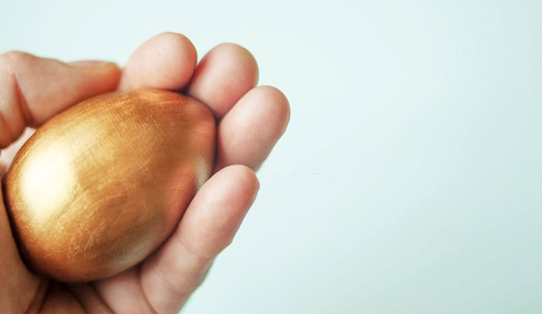 hand having a golden egg to describe gold investment