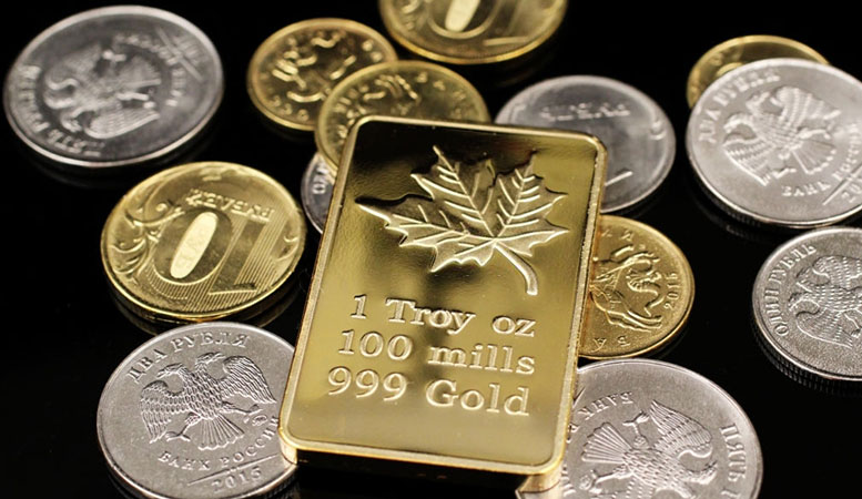 one troy ounce of gold bar with different gold and silver coins on the background featured image
