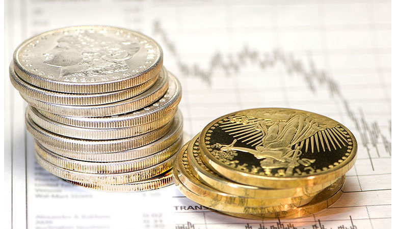 gold and silver coins at the top of stock charts featured image