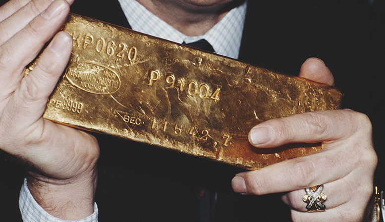 man holding a big gold bar featured image
