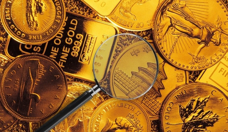 different bullion coins with magnifying glass at the top