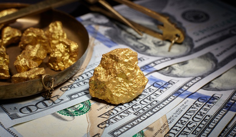 gold nuggets with one hundred dollar bills at the bottom of it