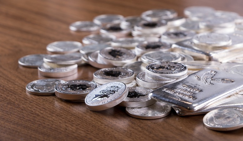 silver coins rounds and bars in a table
