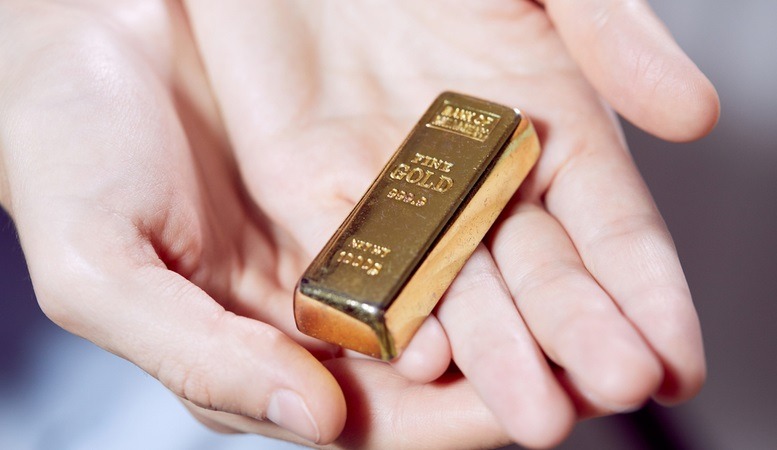 a gold bar handed over to a customer