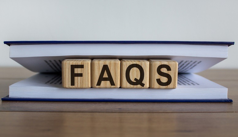faqs on a wooden dice between book pages