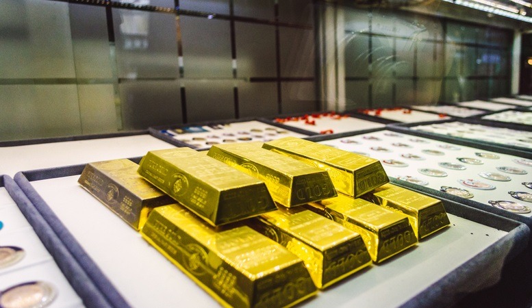 gold bars stacked in a market featured image