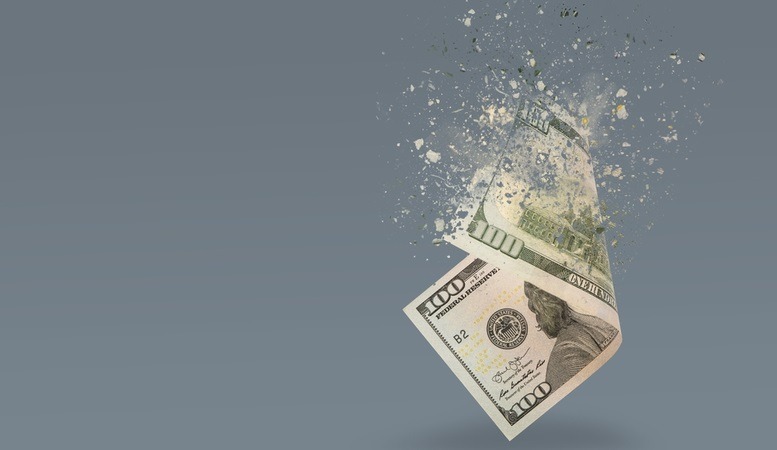 one hundred us dollar bill being disintegrated depicting inflation