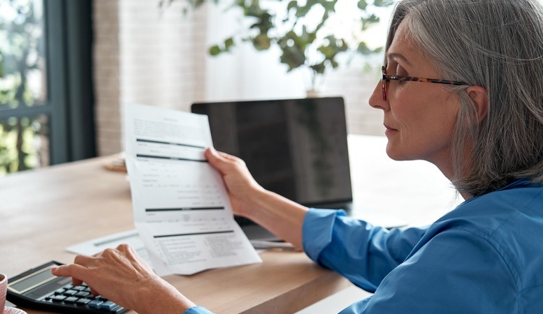 woman reading a document about gold ira fees featured image
