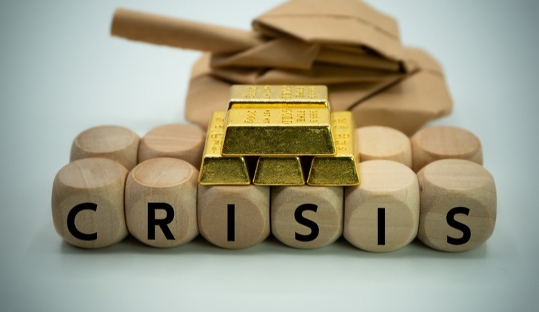 crisis letters on a wooden blocks with gold bars on top of it