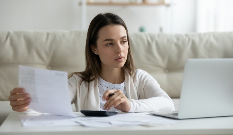 woman looking at her laptop and doing a self directed ira report