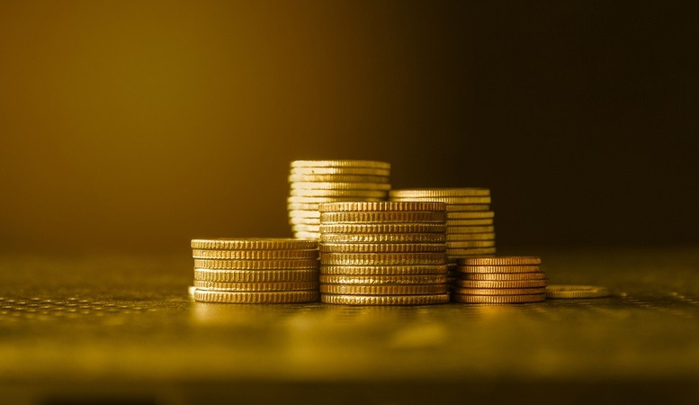 gold coins stacked with a gold background