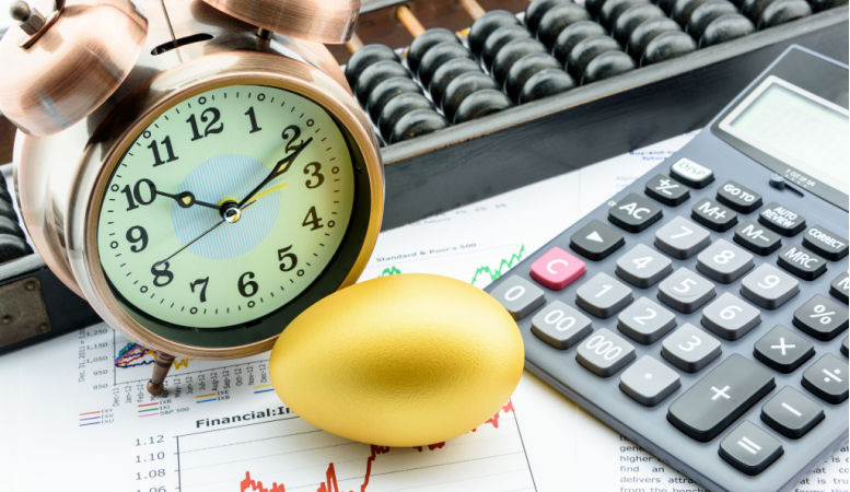 golden egg with clock calculator and abacus on financial reports