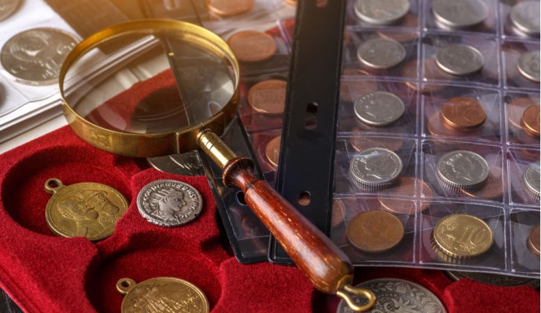 numismatic coins in the album with magnifying glass
