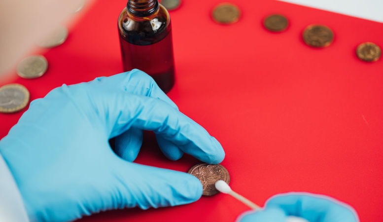 numismatist cleaning ancient coins