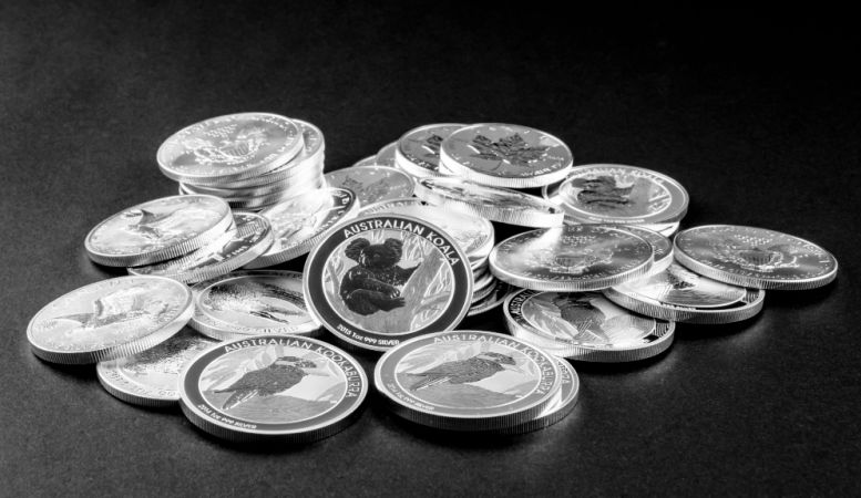pile of silver coins on black background