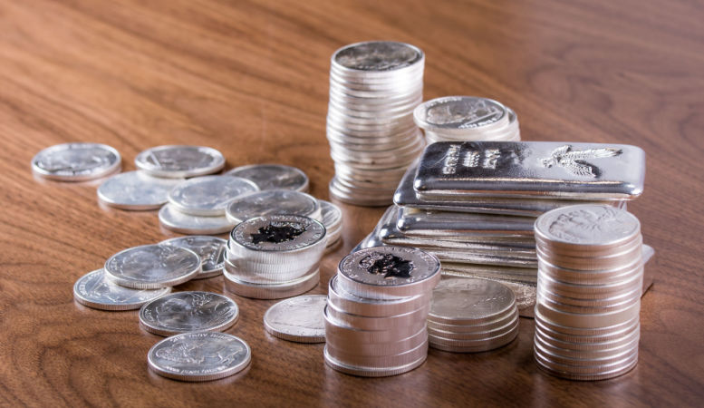 silver bars and silver coins stacked on table featured image