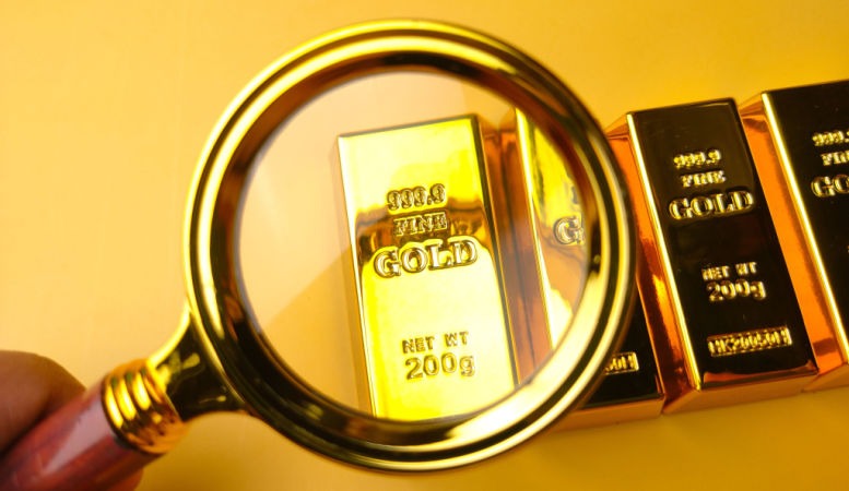 magnifying glass and gold bar on yellow background