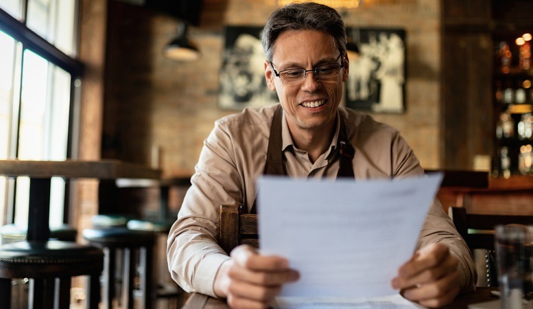 man happily reading his taxes because of deductions