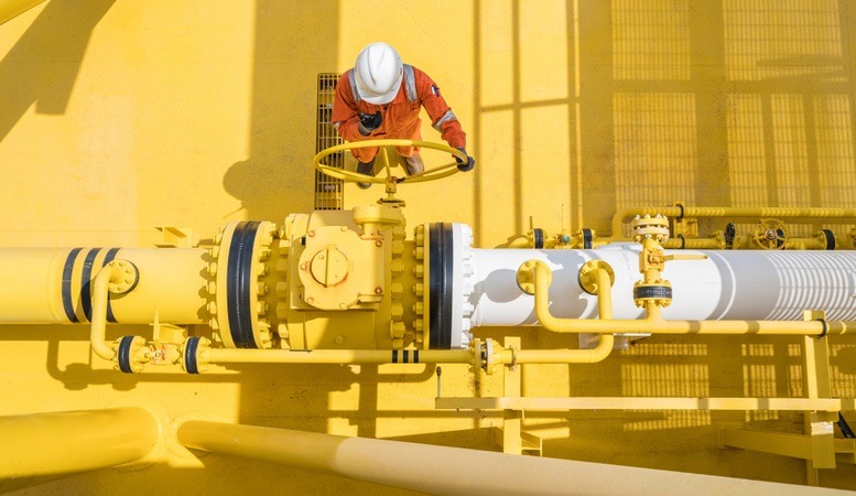 man operating a valve at an oil rig