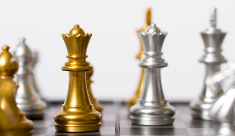 gold chess king facing silver chess king