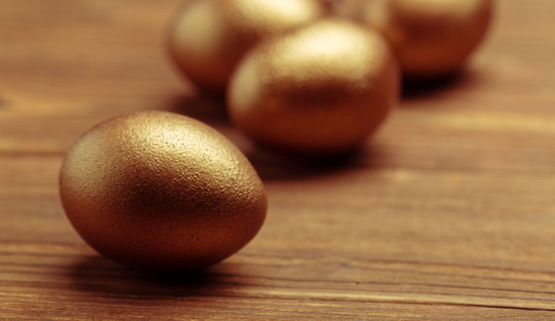 four golden eggs on wooden table