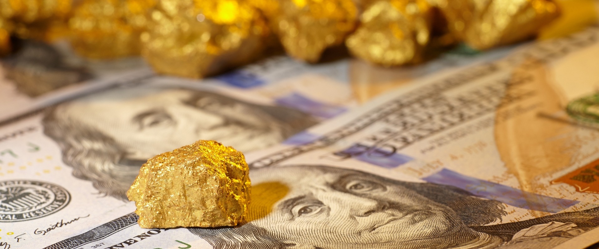 gold nuggets on top of us dollars