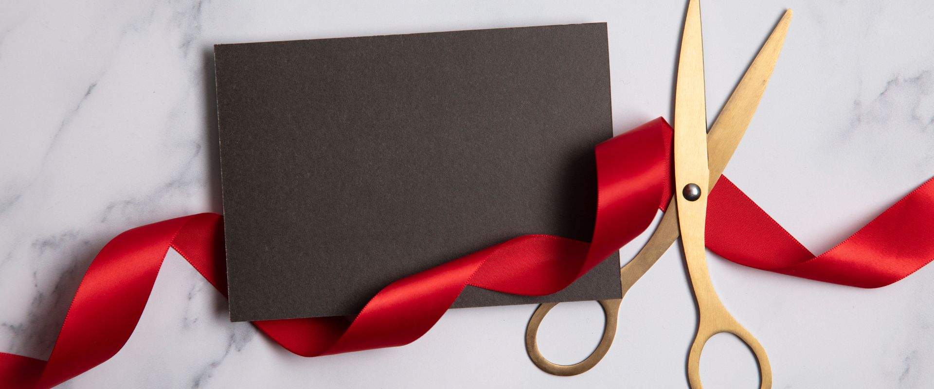 red ribbon and gold scissors