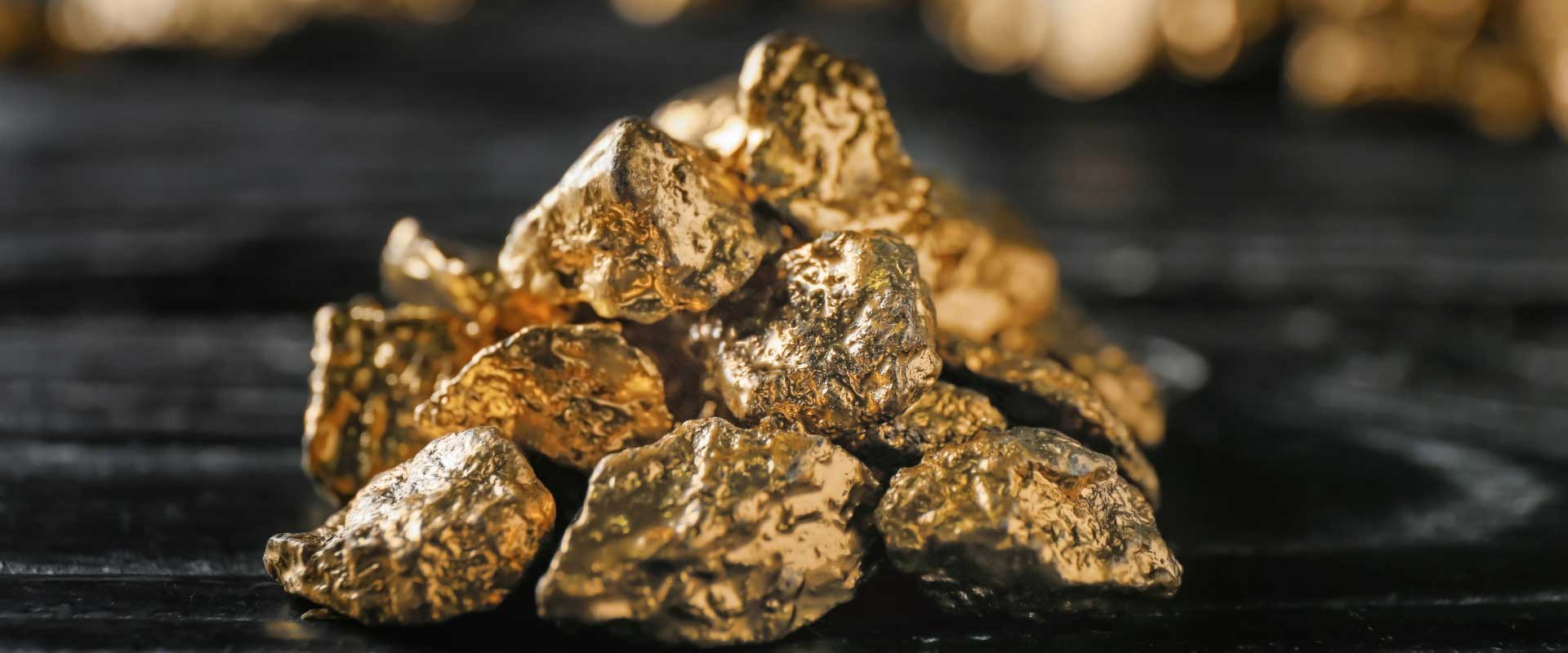 pile of gold nuggets on black surface