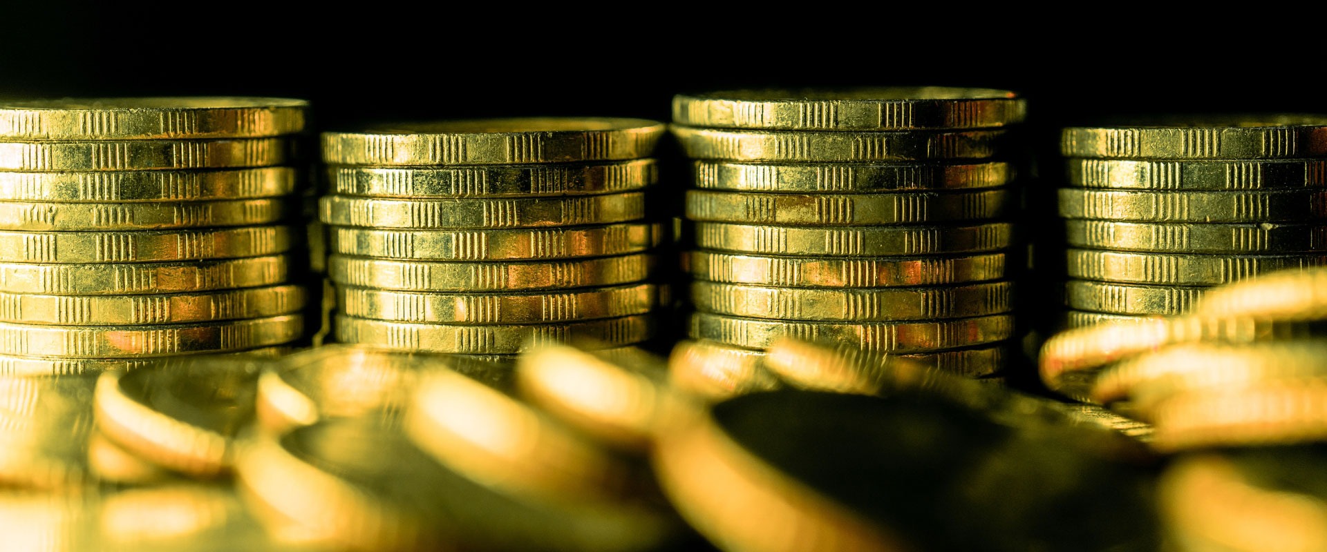 stack of gold coins on dark background