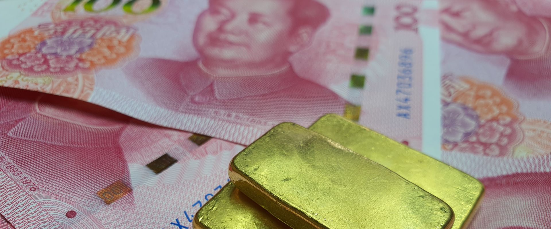 gold bars on top of china bank notes
