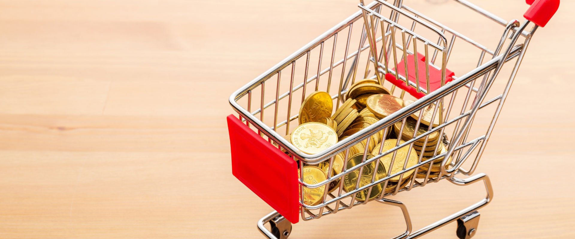 gold coins in shopping cart on table