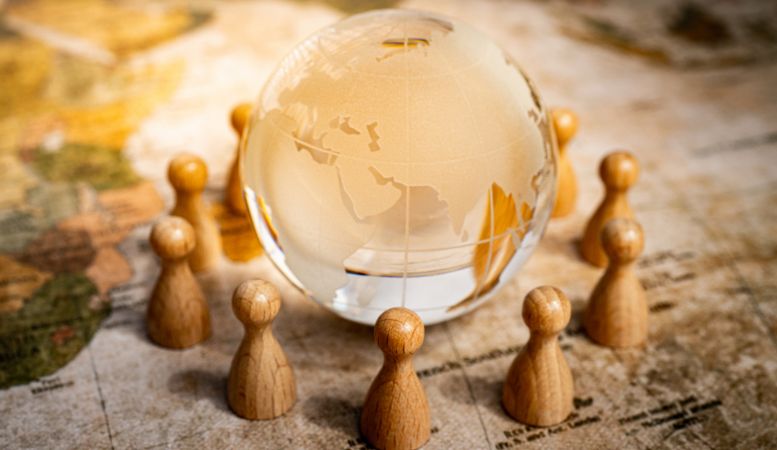 crystal globe surrounded by human wooden figure