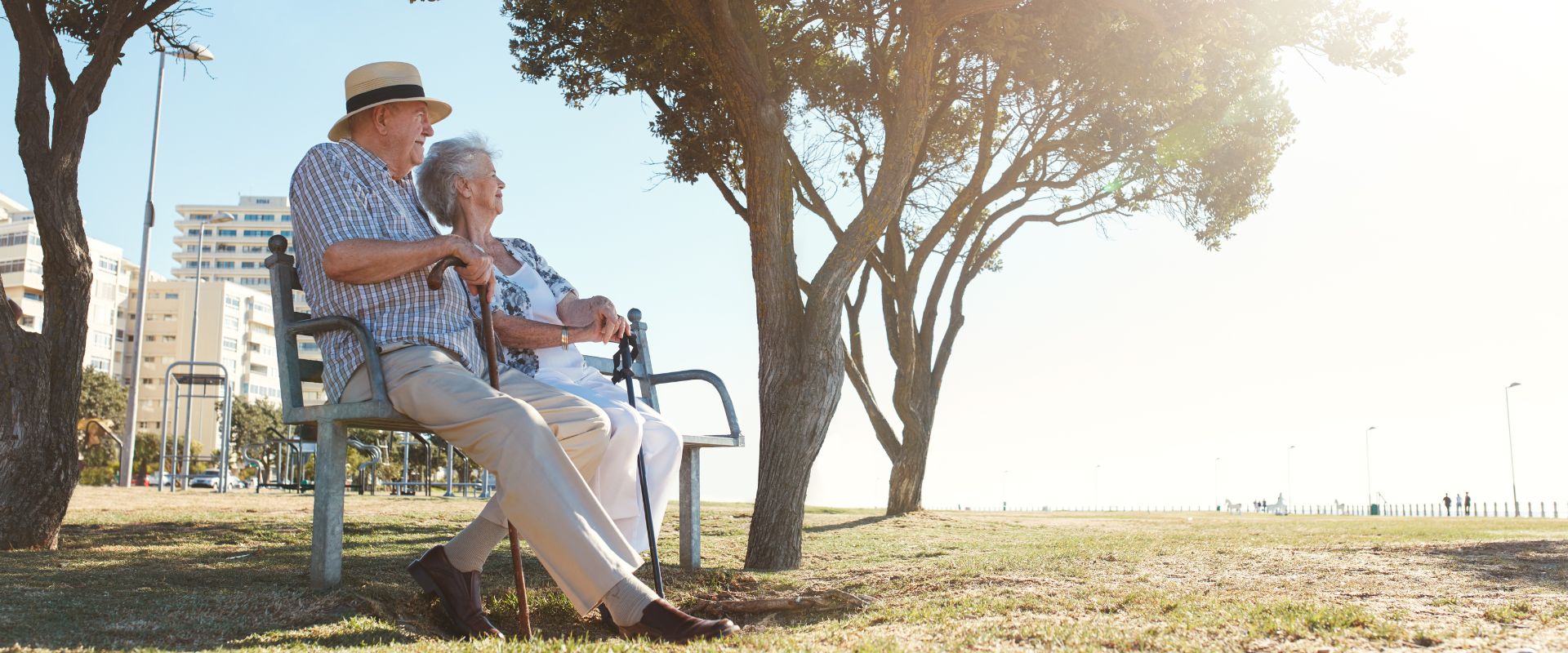retired couple sitting on bench at park