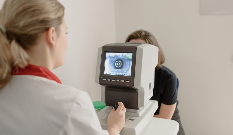 oculist examining vision of patient on eye screener