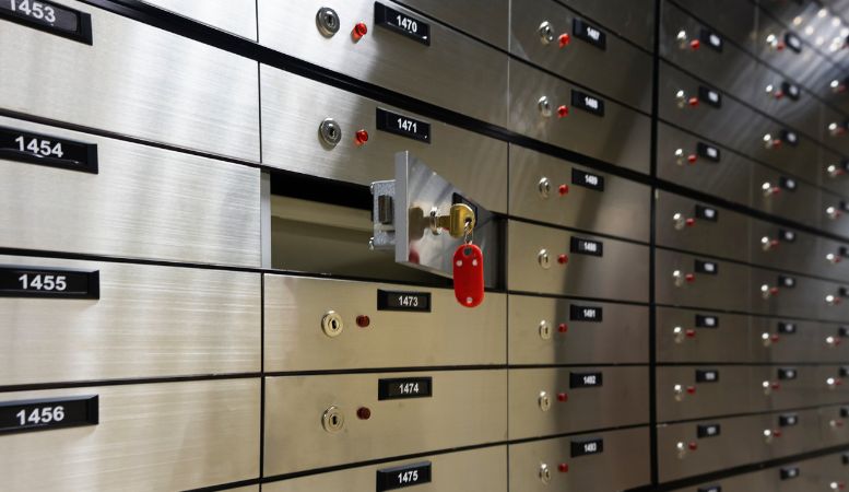 open safe deposit box with key inside bank vault