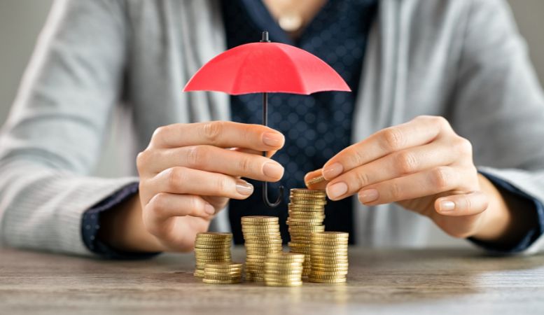 person protecting the stacked coins with an umbrella