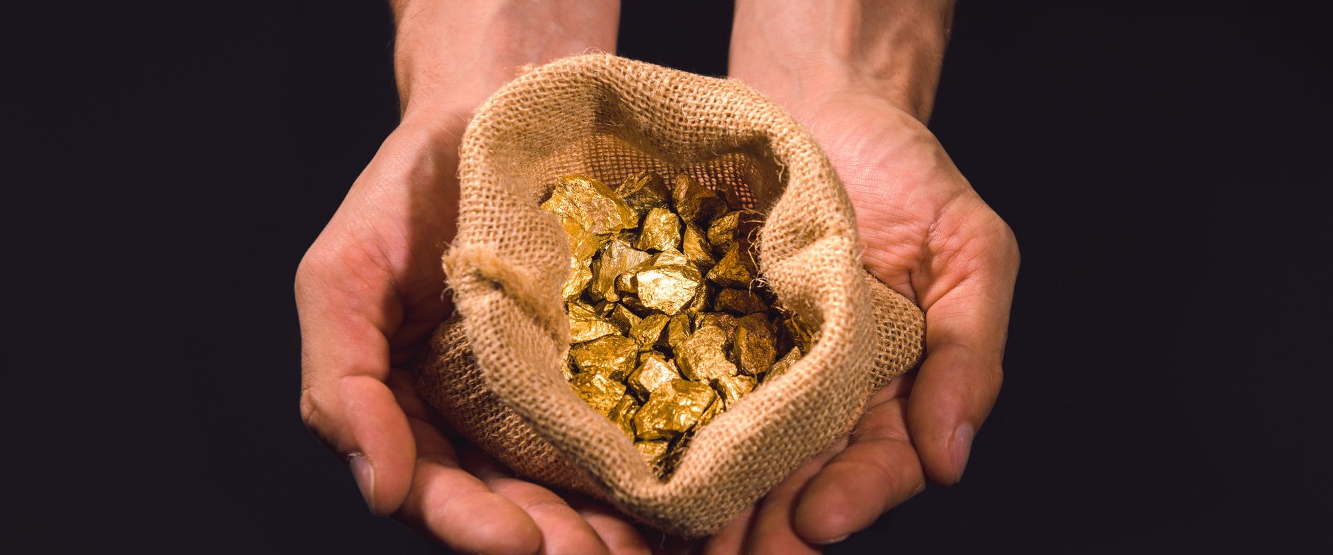 bag of gold nuggets in human hands