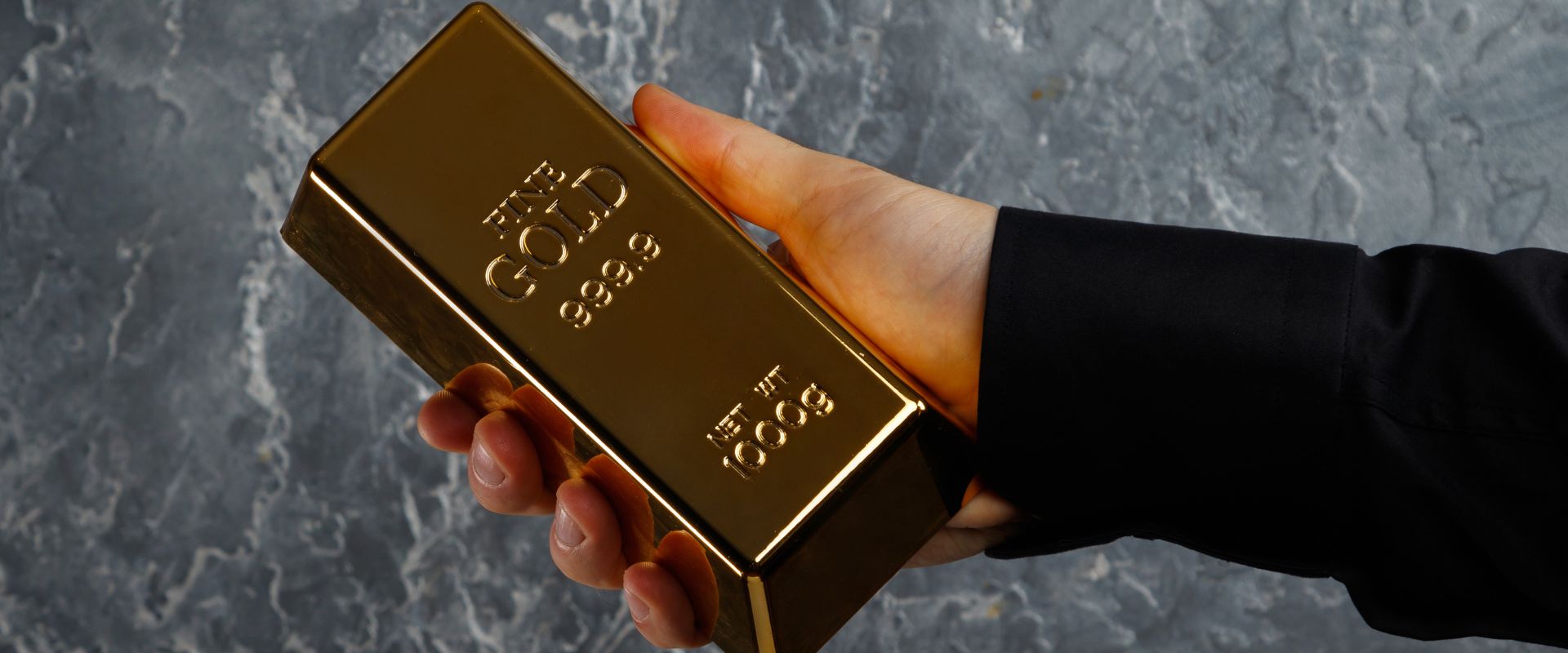 businessman hand holding one kilogram gold bar