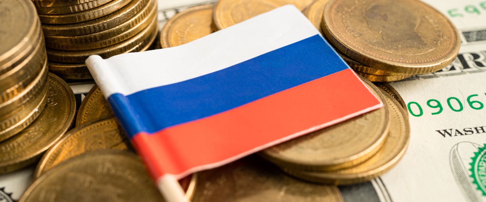 pile of gold coins with Russia flag on dollar background