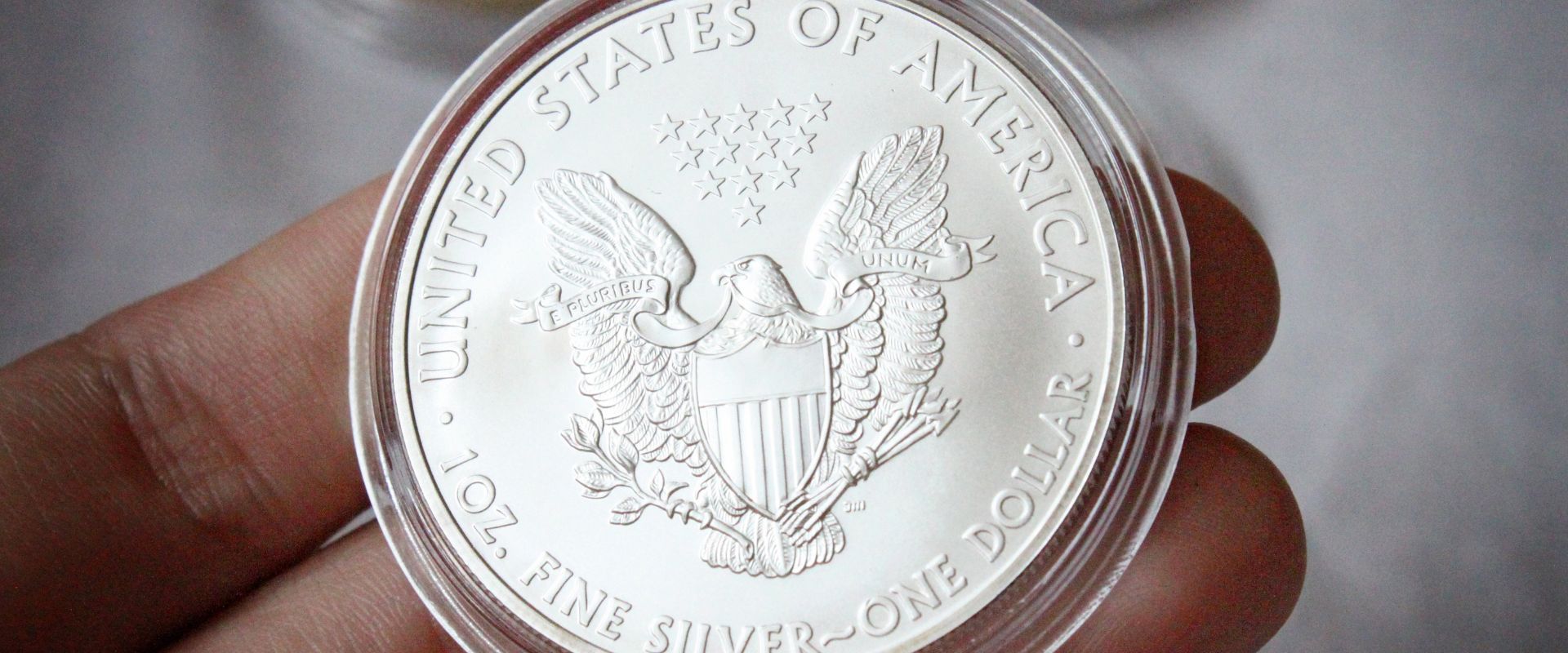 coin collector holding american silver eagle coin