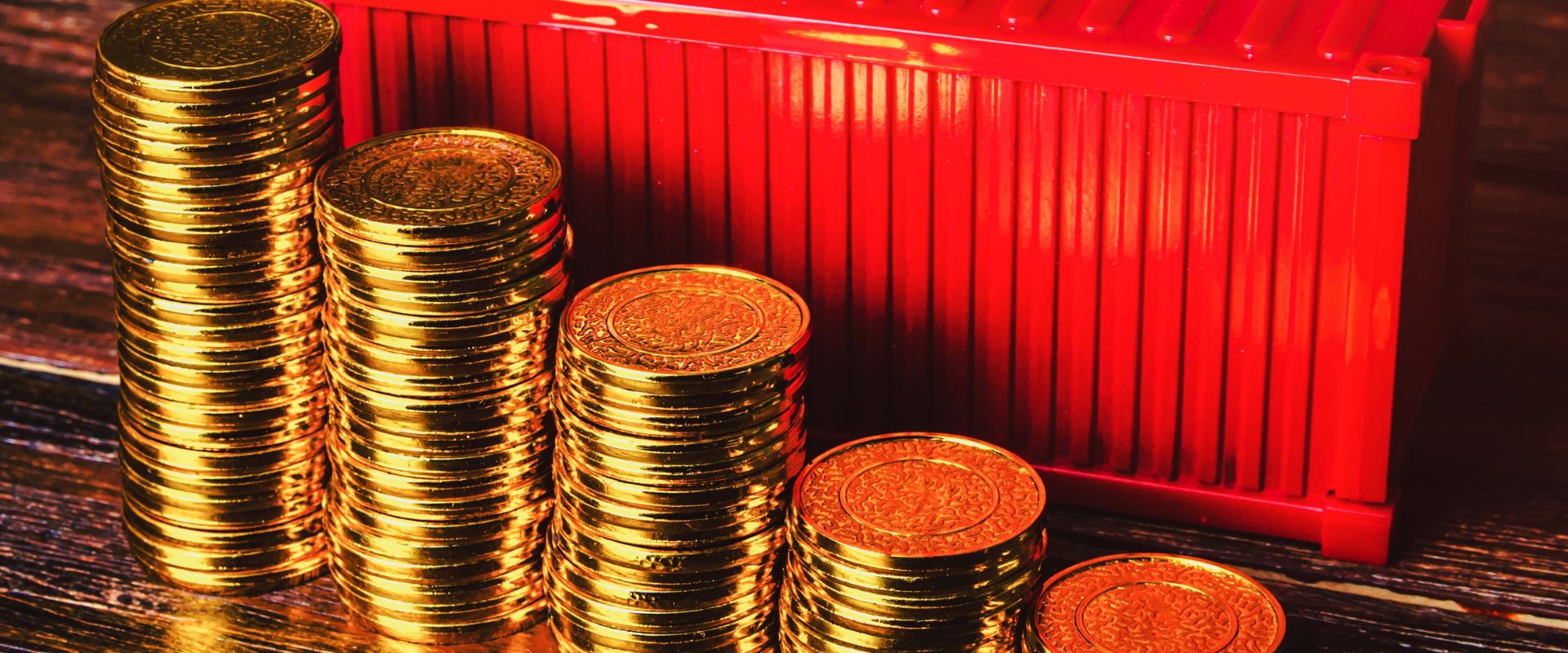 stack of gold coins and container on background