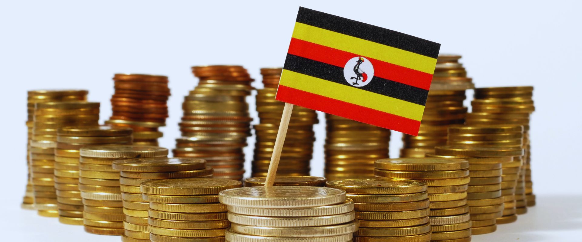 stack of gold coins with Uganda flag