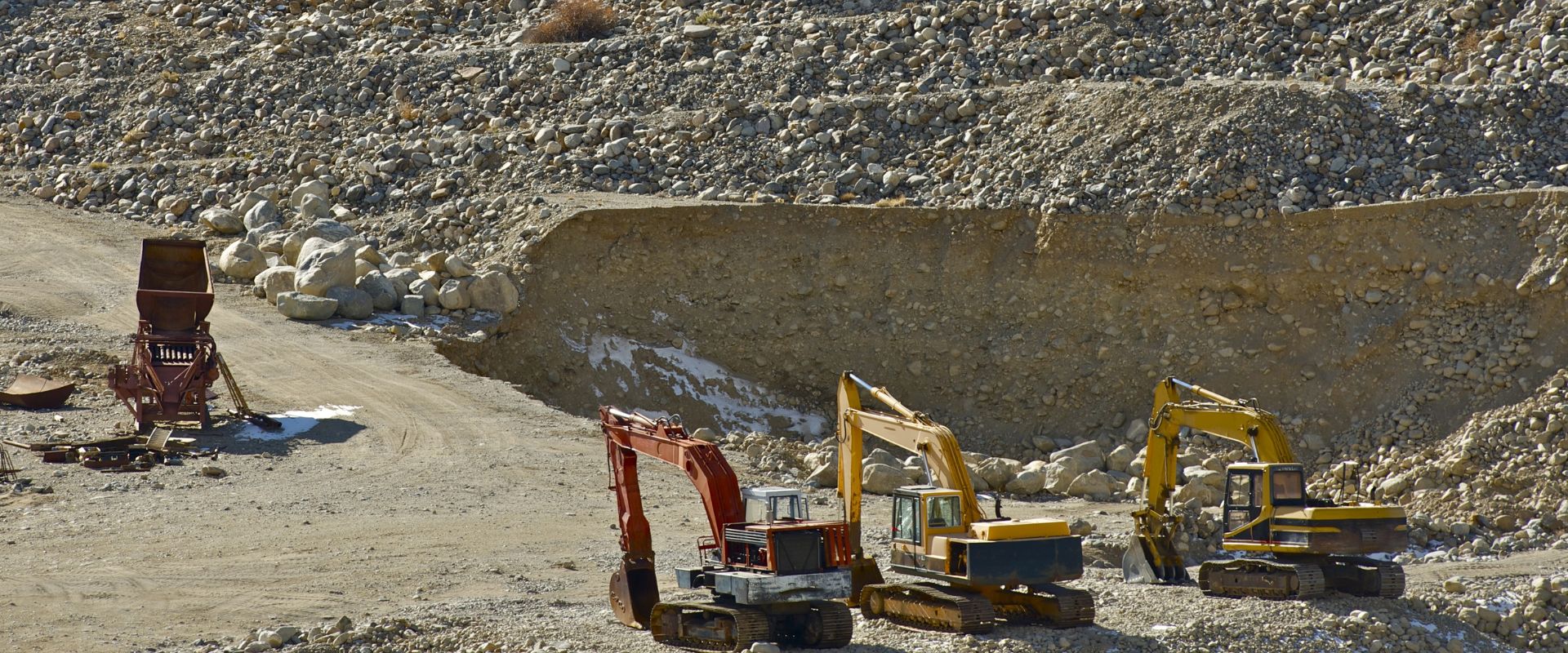 three excavator trucks on gold mining operation