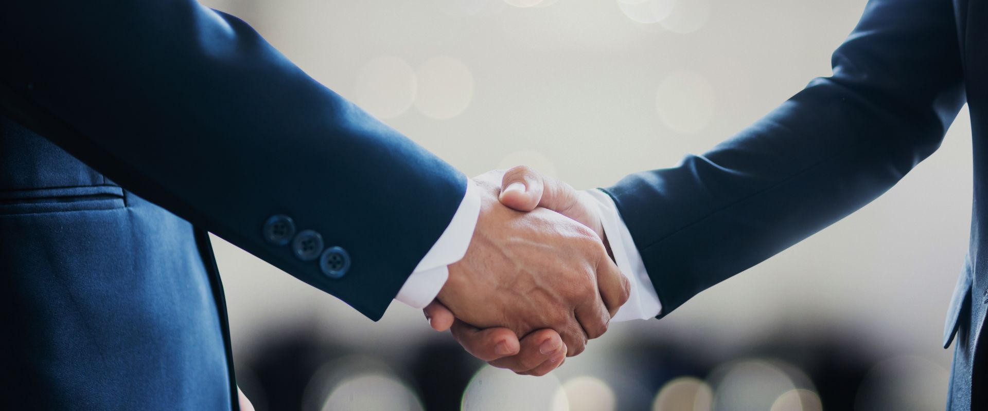 two businessman closing deal with handshake